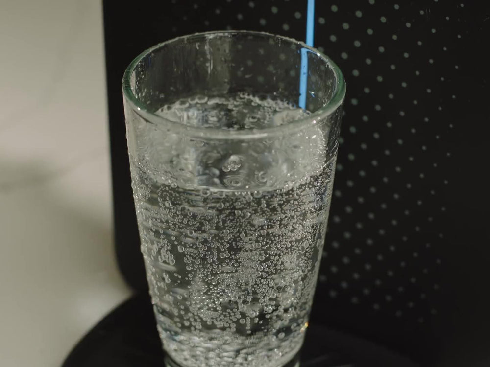 Sparkling water filling a glass at a black Sparkle