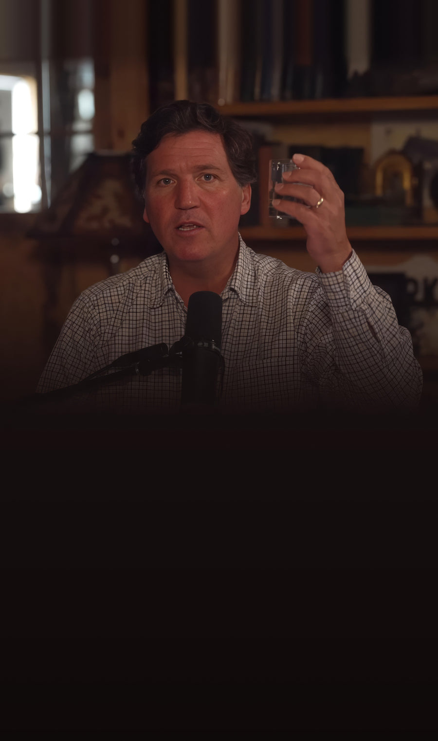 Tucker Carlson holding a glass of water